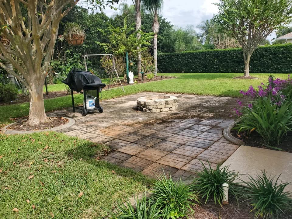 Before: Paver patio around a fire pit, dark and stained with mildew